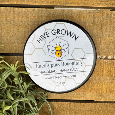 Round container with label on a wooden surface with greenery